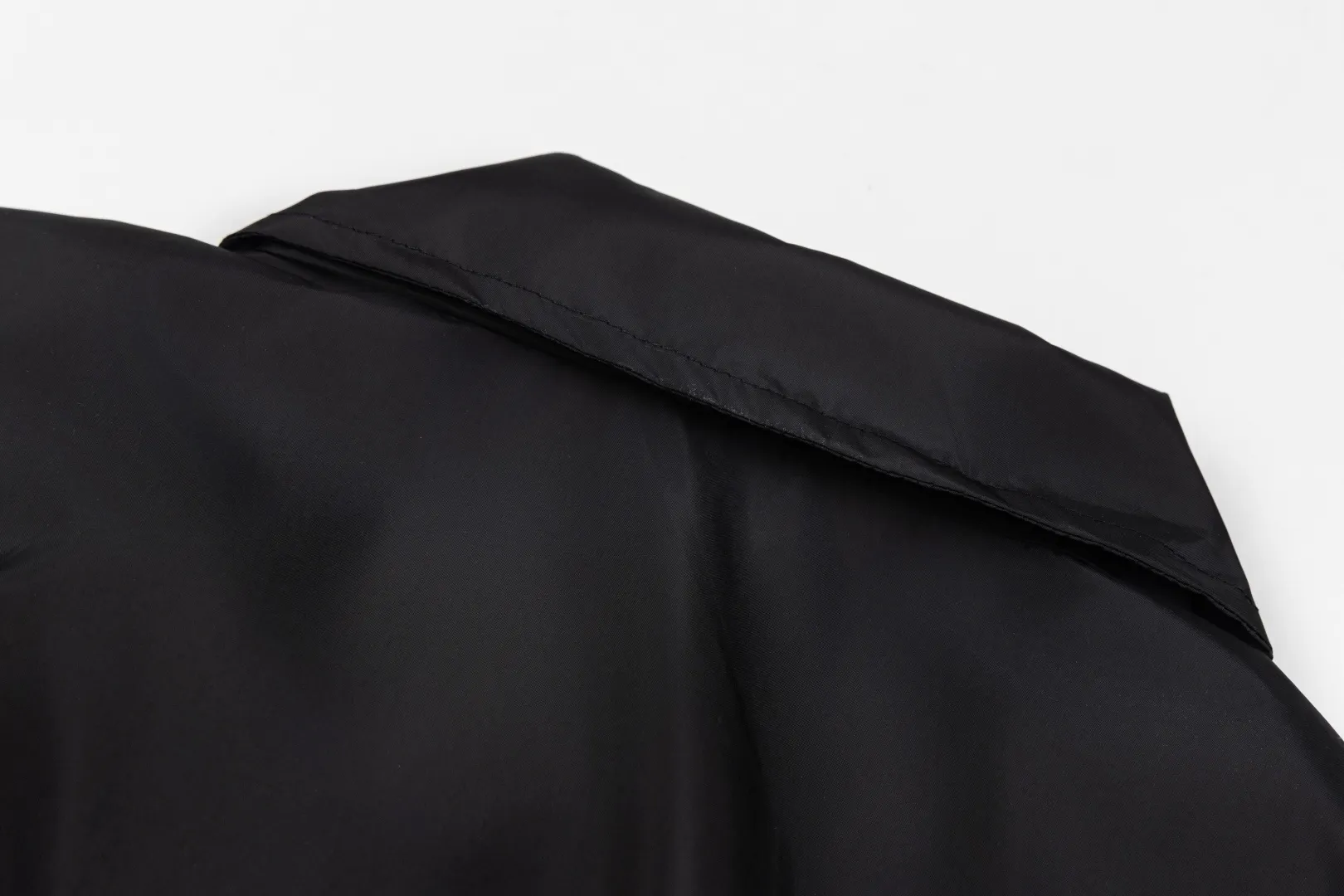 140 Acne Studios Lapel Coach Jacket Glossy nylon back lettering loose windproof jacket Classic lapel coach jacket version, STOCKHOLM back logo, Nordic simple style High-density glossy nylon fabric, light and crisp, windproof and water-repellent, with high-end gloss Metal main zipper + side eyelet details, cuff hem elastic cuffs, lock-type windproof Simple no large print on the front chest, letters on the back as a visual highlight, suitable for street commuting Style number: ST 014# Color: Off-white Black Burgundy Size: S-XL
